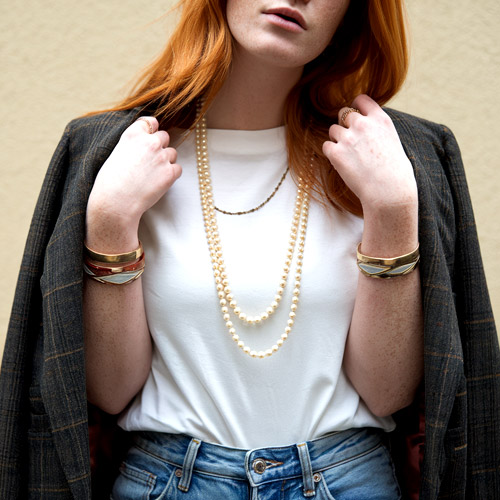 Femme portant un blazer avec un collier de perles vintage